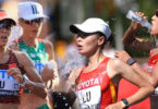 Female marathon runners pouring water over themselves during a race in extreme heat conditions.